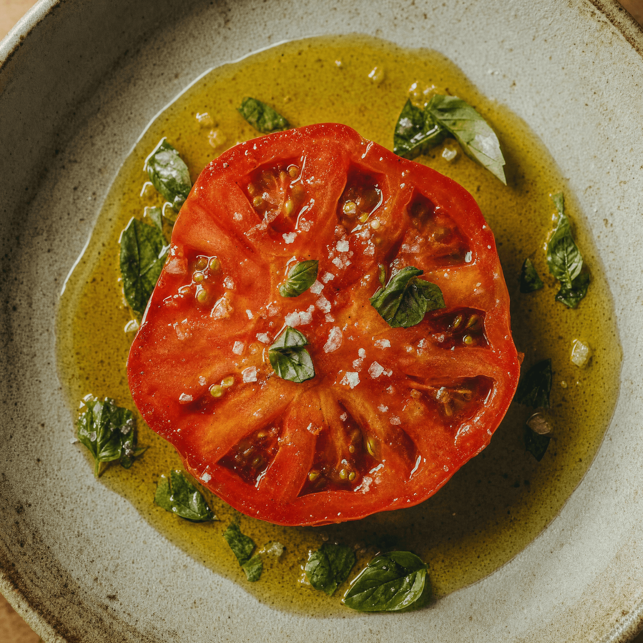Tomatenscheibe mit Olivenöl und Basilikum